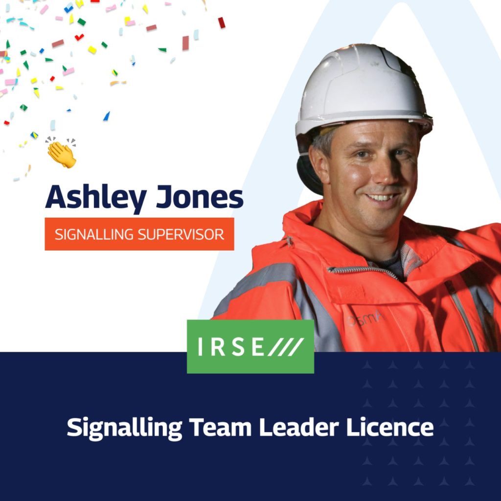 A celebratory graphic announcing Ashley Jones’ achievement of obtaining the IRSE Signalling Team Leader Licence. The image features a professional portrait of Ashley in a high-visibility jacket and hard hat on the right, with colourful confetti in the top left corner. His name and title, “Signalling Supervisor,” are displayed on the left with a small clapping hands emoji. The IRSE logo is prominently shown below, along with the text “Signalling Team Leader Licence” in bold white letters on a dark blue background.