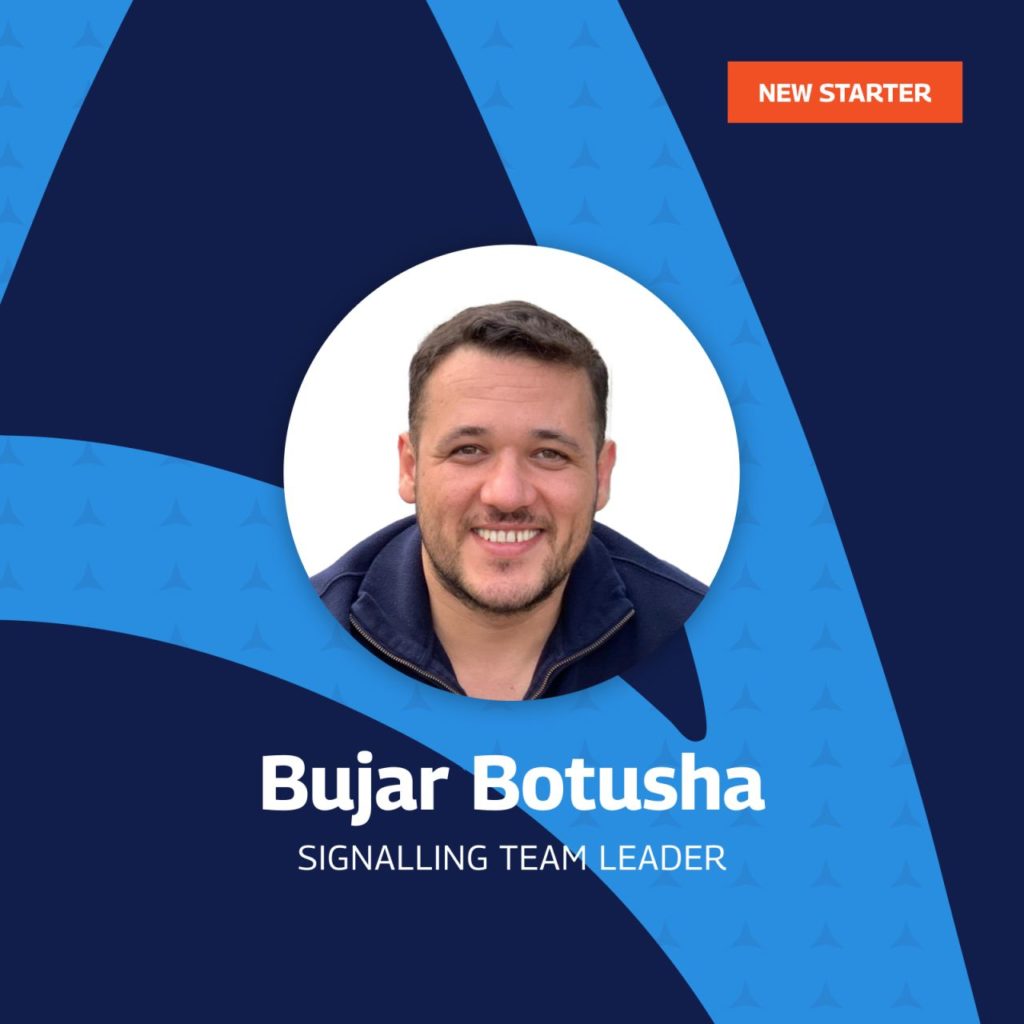 A welcoming graphic introducing Bujar Botusha as the new Signalling Team Leader. The image features a professional portrait of Bujar smiling, centered within a circular frame. The background is a sleek combination of dark blue and light blue, with a subtle pattern. A bright orange tag in the upper right corner reads “NEW STARTER.” Bujar’s name and role are prominently displayed beneath the portrait in bold white text.