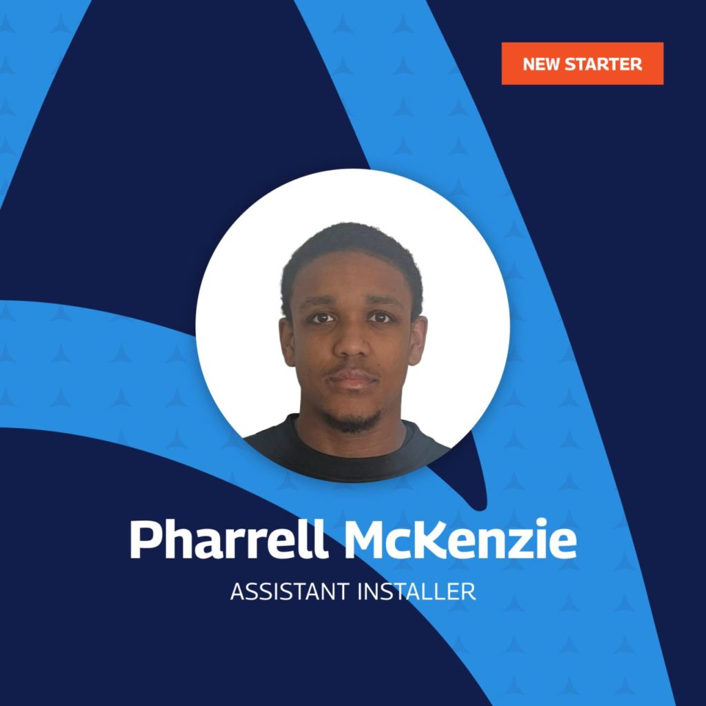 The image is a professional introductory graphic for a new employee named Pharrell McKenzie, who has been appointed as an Assistant Installer. The design features a circular portrait of Pharrell centered against a blue geometric background with a subtle pattern of upward-pointing arrows, symbolizing progress or ascent. An orange banner at the top right corner of the image declares "NEW STARTER," highlighting his recent addition to the team.